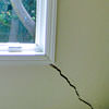 A long, diagonal crack that begins at a window corner of a Bolton home